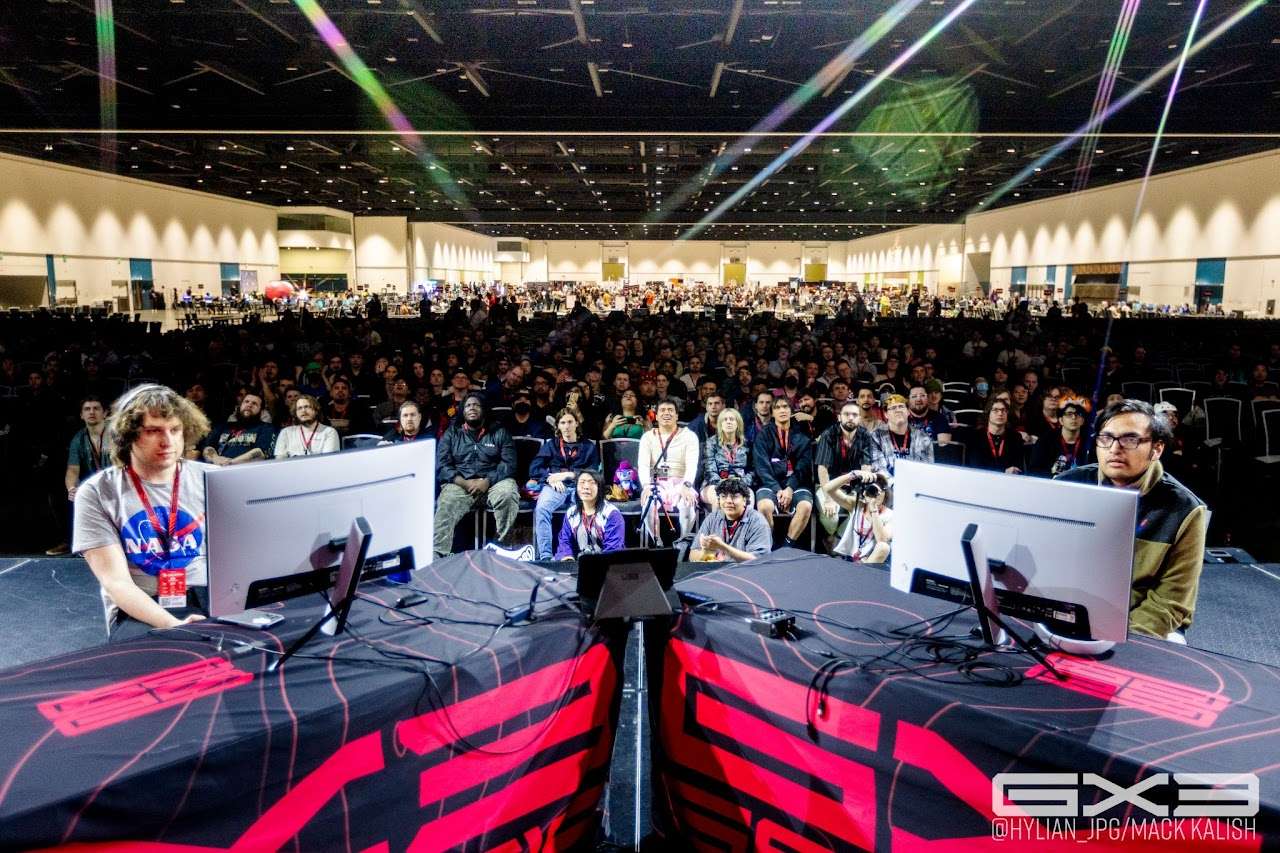 Two competitors face a packed audience from the GENESIS X3 main stage